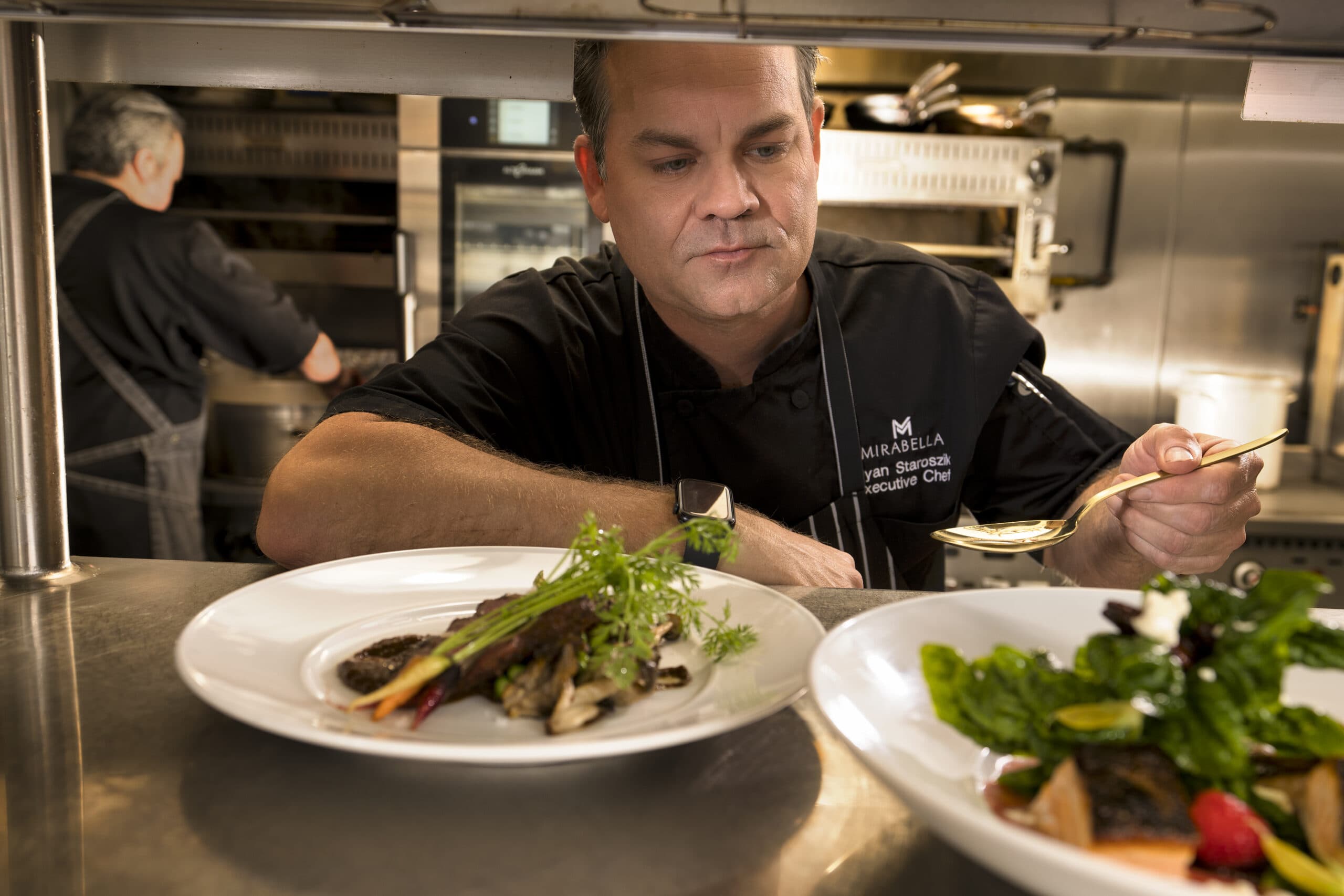 A Mirabella at ASU chef finishes a dish with a gourmet garnish.